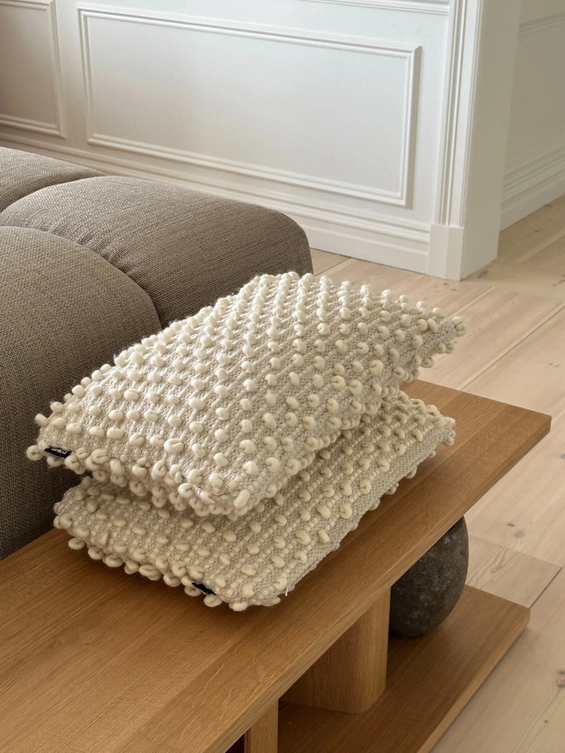 Tuhlin Cushion by tinted laying on table