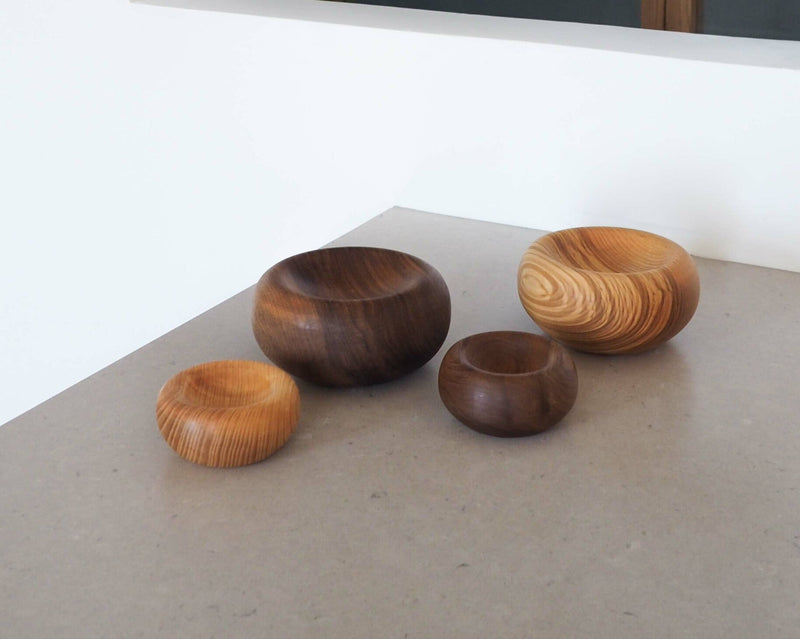 Four wooden bowls of different sizes on a light surface